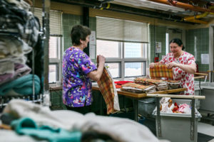 women folding fabric